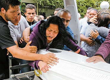 Amparada pelo pai, Tamires dos Santos Silva, 22, chora sobre o caixo do filho de apenas um ano e sete meses de idade