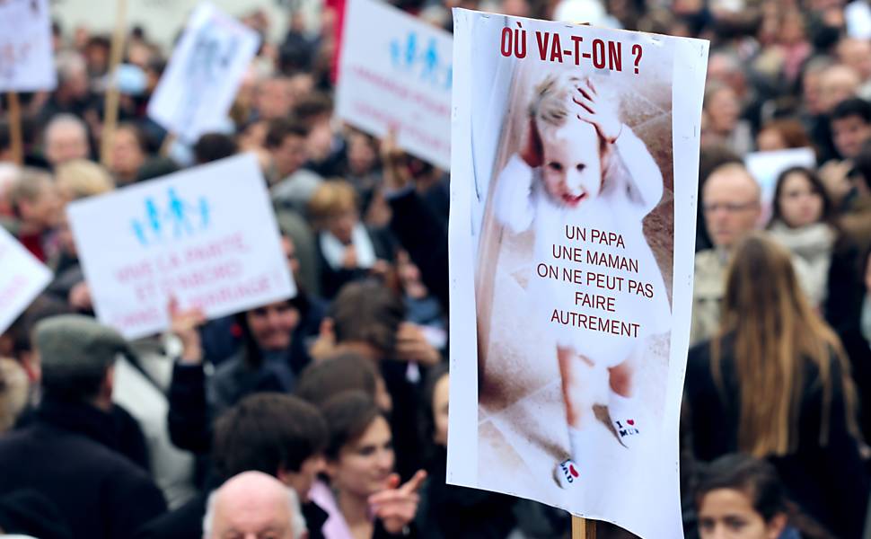 Manifestantes exibem cartazes em protesto ao projeto de lei que autoriza o casamento gay e a adoção por casais do mesmo sexo na França