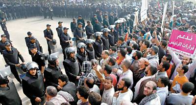 Manifestantes pr-governo protestam em frente  Suprema Corte Constitucional no Cairo sob o olhar de policiais
