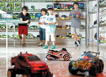 Meninos pilotam carros de controle remoto em loja em SP; Natal  a 2 data mais importante para o setor de brinquedos