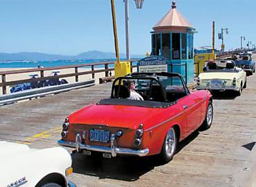 Carros antigos adentram o Stearns Wharf, o per de Santa Barbara