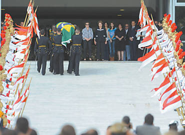Observados pela viúva de Niemeyer e pela presidente Dilma Rousseff, soldados carregam caixão com o corpo do arquiteto no Palácio do Planalto