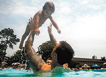 Em meio ao calor, o pequeno Gabriel Frega, 2, brinca como tio Srgio Frega, 30, na piscina do Clube Atltico Juventus