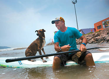 O co Parafina na prancha com Picuruta Salazar, em Santos; h um ano, surfista o levou para o mar pela primeira vez
