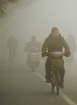 Ciclistas atravessam a "nuvem" de poluio na cidade de Huaibei, na provncia de Anhui
