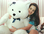 Sandy com o urso de pelúcia em seu quarto