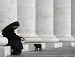 Gato preto caminha ao lado de freira na Praça São Pedro, no Vaticano; cardeais iniciam conclave nesta terça-feira 