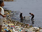 Crianças buscam materiais recicláveis entre lixo acumulado às margens de rio em Manila (Filipinas); hoje é celebrado o Dia Mundial do Meio Ambiente