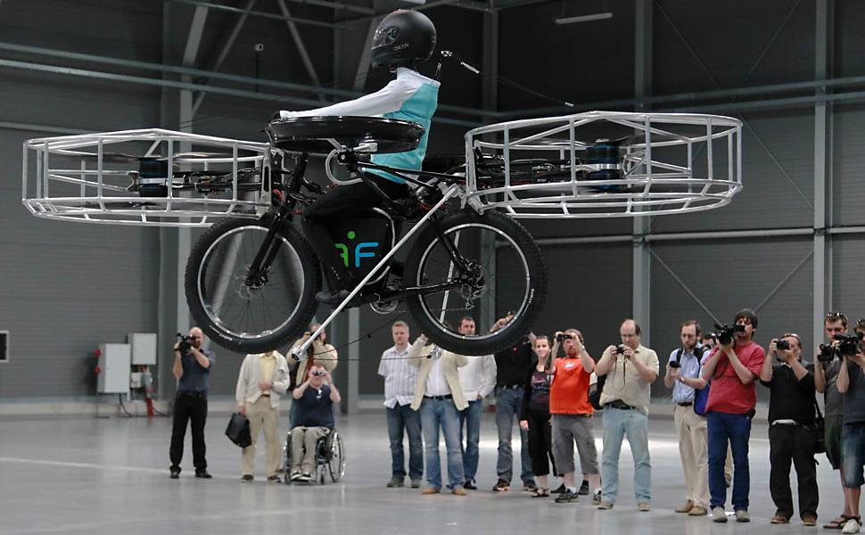 Jornalistas acompanham a apresentação da bicicleta voadora desenvolvida por designers tchecos, em Praga; veículo decolou e pousou em segurança depois de voar por 5 minutos