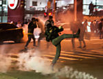 Manifestante chuta bomba de efeito moral jogada por policiais; várias pessoas ficaram feridas no confronto