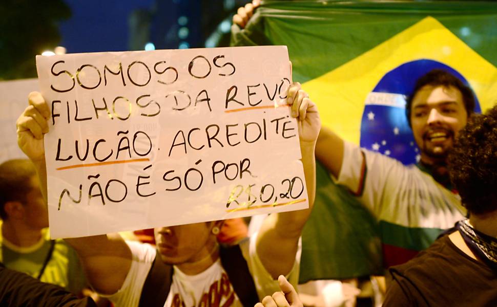 Manifestante exibe cartaz contra o aumento do preço da passagem do transporte público no Rio