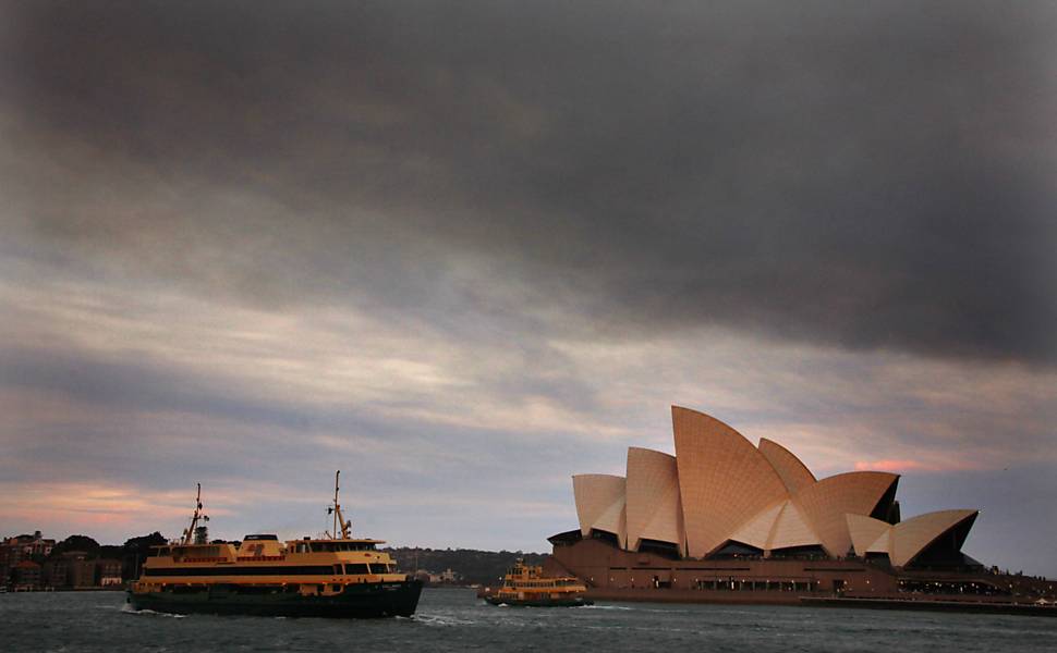 Cinzas de incêndios florestais s?o vistos no céu sob o Opera House, símbolo de Sydney que completa 40 anos neste domingo Leia mais