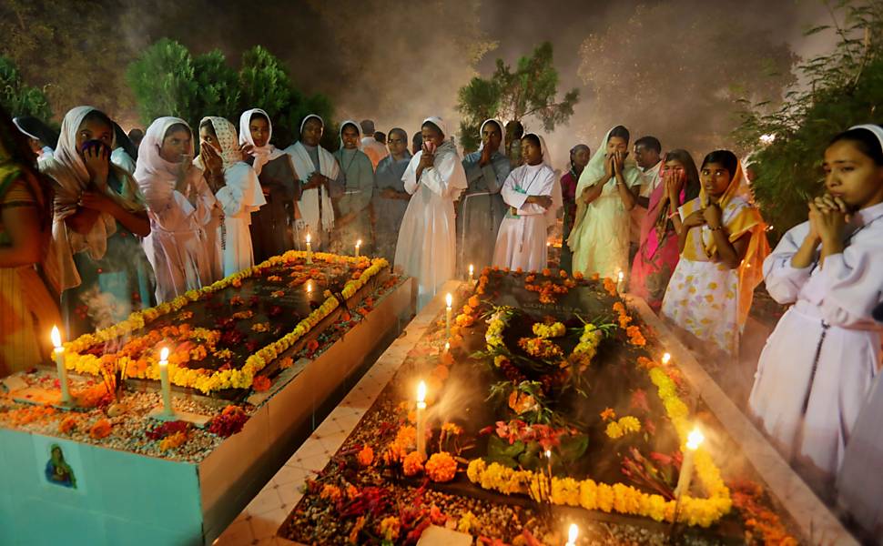 Freiras cristãs oram perto de túmulos no Dia de Finados, em Bhopal, Índia