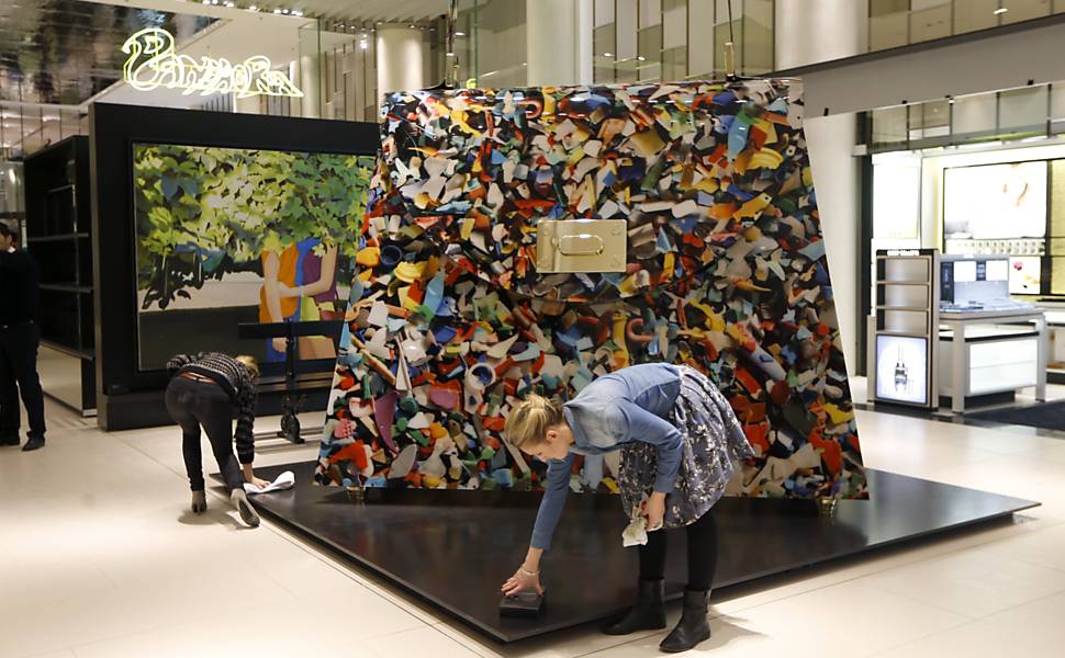 Funcionária lustra fecho de bolsa gigante antes de evento do museu do Louvre em Paris, na França 