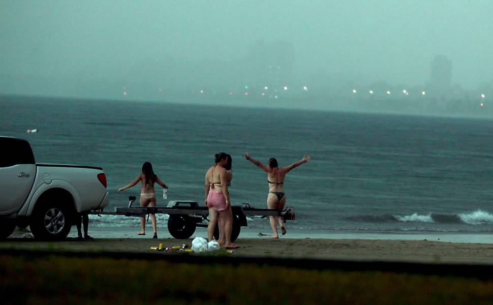 Mulher abre os braços e entra na água na praia da Enseada, no Guarujá (SP), segundos antes de ser atingida por um raio e morrer 