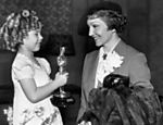 Shirley Temple (à esq.) recebe os parabéns de Claudette Colbert por seu Oscar especial, em 1935