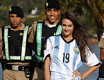 Em frente o estádio Mineirão, em Belo Horizonte, modelo posa para foto junto à policiais militares