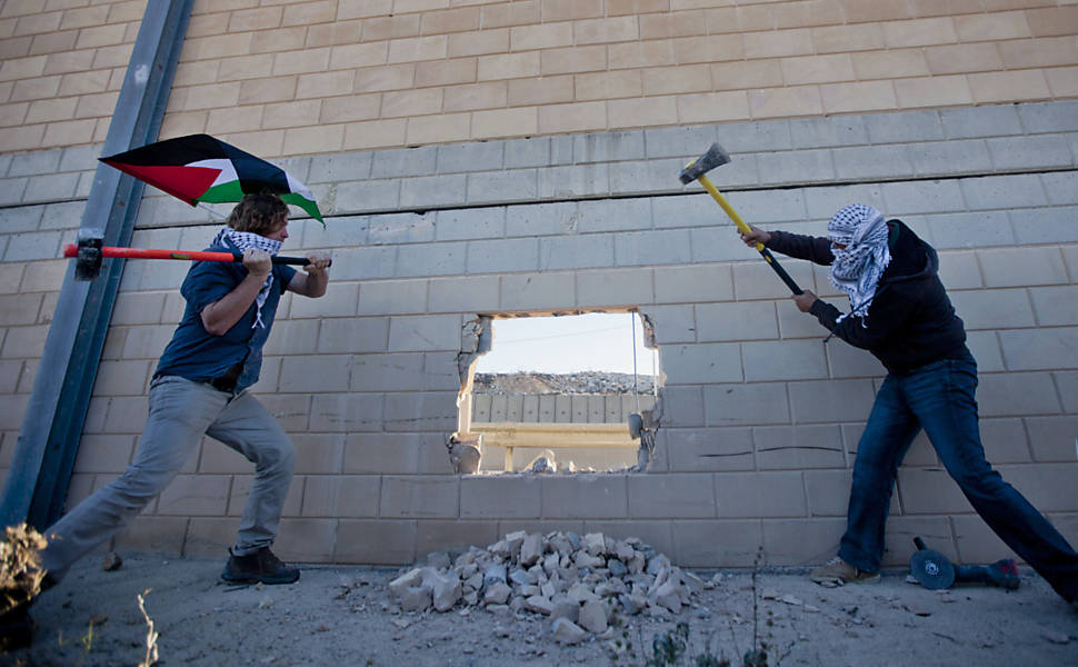 Jovens palestinos quebram muro de Israel
