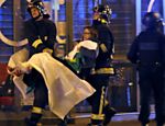 Bombeiros carregam mulher ferida próximo a sala de concertos Bataclan, em Paris