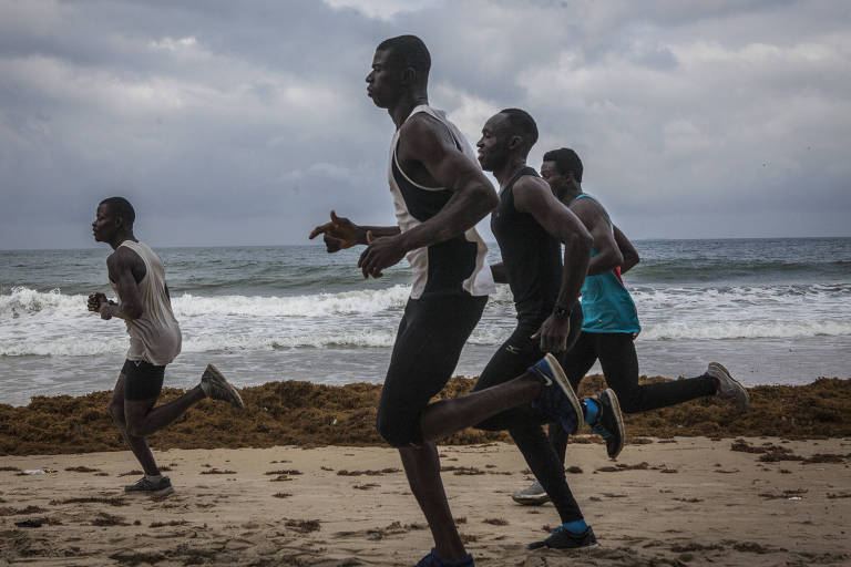 Atletas correm na praia de Aberdeen, em Freetown, Serra Leoa