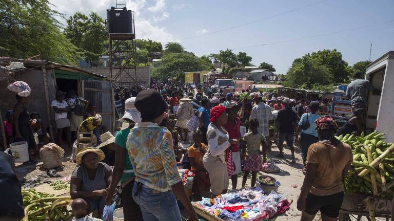 Haitianos fazem compras em feira livre de Montrouis, no norte do pas