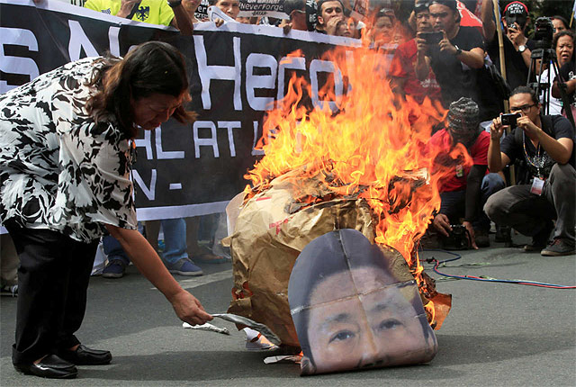 A protester burns an image of former Philippine dictator Ferdinand Marcos along a main street at Taft avenue, metro Manila, Philippines November 18, 2016. REUTERS/Romeo R.