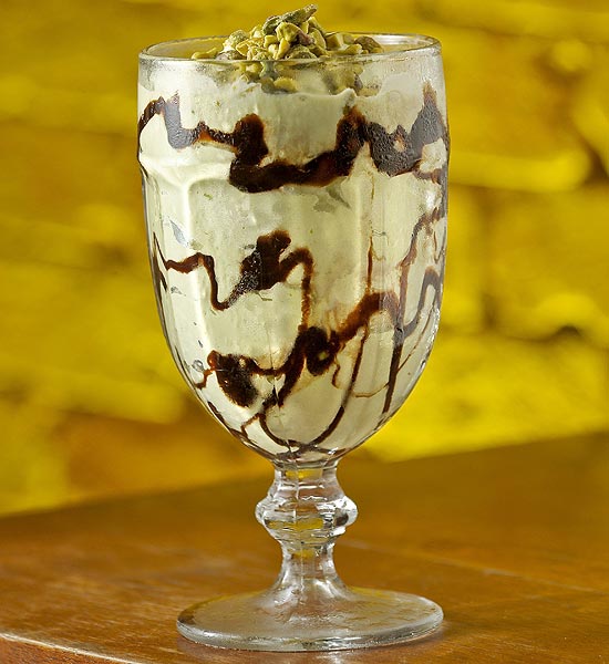 Milk-shake de pistache (foto) mistura sorvete de creme, pasta de pistache italiana, calda de chocolate e farofa