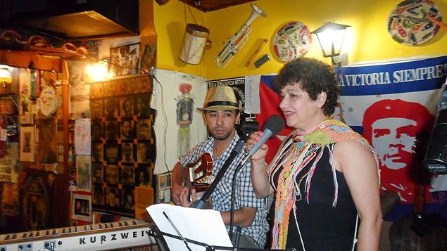 Artistas se apresentam no Bar do Frango, na zona leste, em palco decorado com mensagens e pôsteres de filmes e de artistas da MPB