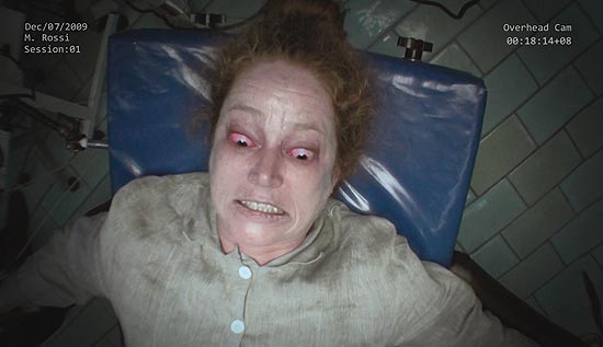 Maria Rossi(Suzan Crowley) durante tentativa de exorcismo em um quarto da prisão psiquiátrica