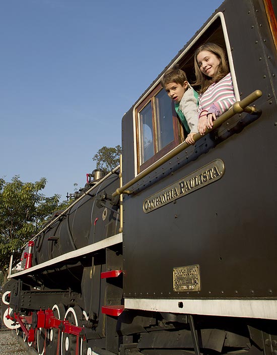 João, 8, e Isabel Trevisan, 12, brincam na locomotiva do Centro Cultural Catavento, na zona leste de São Paulo