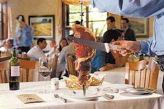 Garçom serve carne na churrascaria Fogo de Chão, em São Paulo; rede foi vendida por US$ 400 milhões a fundo americano (Fernando Moraes - 08.jul.08/Folha Imagem)