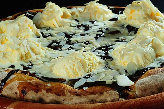 Pizza fonduto Bravo! Pizza Bar (foto) tem massa coberta com caramelo, fondue de chocolate, amêndoas e sorvete de creme