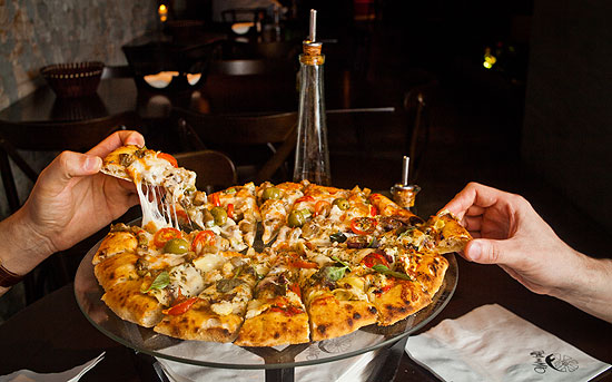 Na Pizza na Mão (foto), as redondas são servidas sem talheres e sem pratos