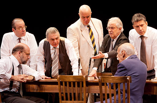 Atores em cena da peça "12 Homens e uma Sentença", que mostra jurados discutindo sobre a condenação ou não de um rapaz