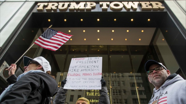 Supporters including one wearing a President Donald Trump mask walk past Trump Tower during a March 4 Trump rally on Fifth Avenue, Saturday, March 4, 2017, in New York. (AP Photo/Mary Altaffer) ORG XM