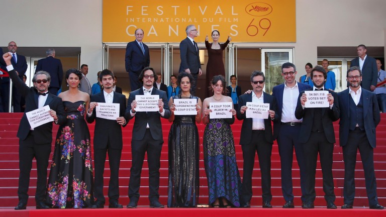 Director Kleber Mendonca Filho and cast members hold placards on the red carpet as they arrive for the screening of  the film "Aquarius" in competition at the 69th Cannes Film Festival in Cannes