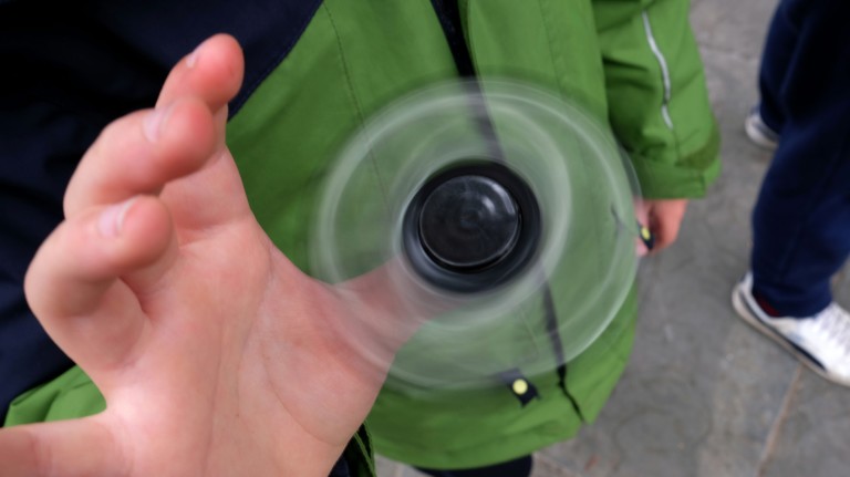 Eight-year-old Tom Wuestenberg plays with a fidget spinner in a park in New York on May 23, 2017.  It was supposed to calm nerves, relieve stress and improve concentration but the new-anti fidget toy 