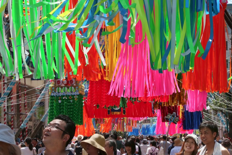 People walk under colorful paper streamers decorated at a shopping street to celebrate the Tanabata Star Festival in Hiratsuka, near Tokyo, Friday, July 7, 2017. According to legend, deities Orihime (
