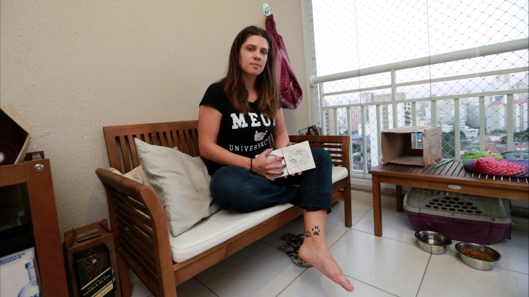 A fisioterapeuta Priscila Kerye, 31, mostra o molde de gesso e a tatuagem com pegadas de seu gato