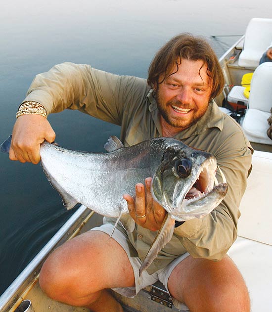 Bilogo tenta domar um peixe capturado durante uma pescaria no rio So Benedito, no sul do Par
