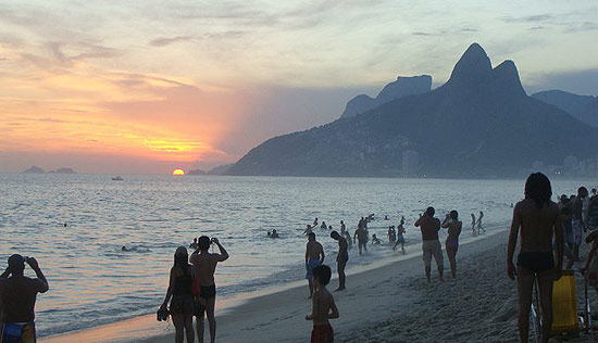 Da praia do Arpoador, banhistas aplaudem pôr-do-sol no horizonte do morro Dois Irmãos, no último domingo