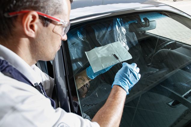 O instalador de vidro automotivo da CarGlass, Raul Ferreira, 38, durante reparo em para-brisa de automvel na residncia de cliente
