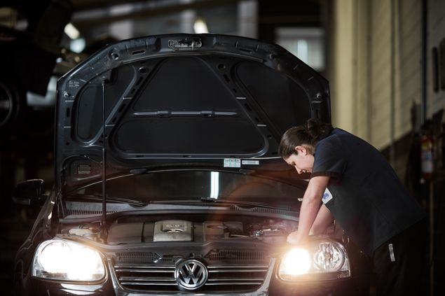 Mecnica Evelin Gefari substitui lmpada modelo H7 de um Volkswagen Jetta, em oficina em SP