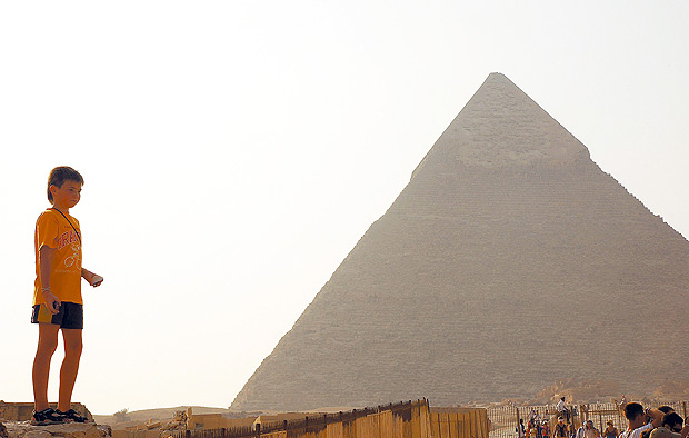 ORG XMIT: 044201_0.tif CAIRO, EGITO, DATA DESCONHECIDA: Menino brinca perto de Quéops, a maior das três pirâmides de Gizé, construída para ser a tumba do faraó Quéops (2251 a.C. a 2528 a.C.); ele escolheu um local ao norte de Mênfis, capital do Egito na época, para construir seu complexo funerário. (Foto: Guilherme Tosetto/Folhapress)