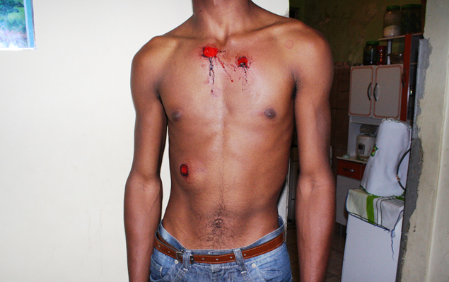 Imagem feita por morador do Alemão, no Rio, mostra jovem atingido por balas de borracha durante confronto com o Exército