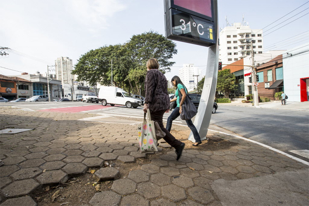 Pedestres passam por buraco deixado por relógio na avenida Brás Leme, na zona norte de SP