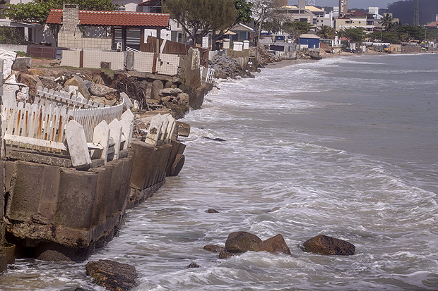 Água do mar alcança e derruba muros de construções na praia dos Ingleses