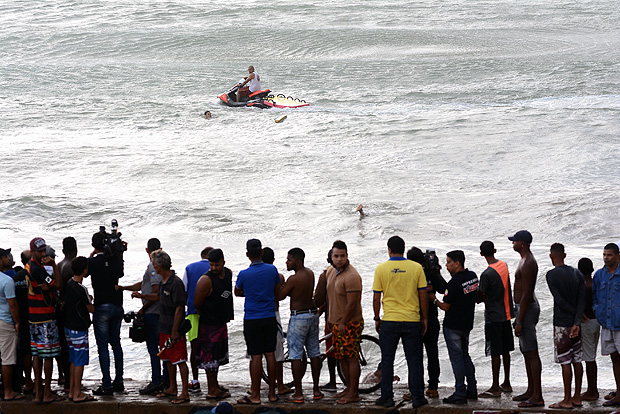Banhistas acompanham resgate às vítimas de queda de helicóptero da TV Globo, no Recife