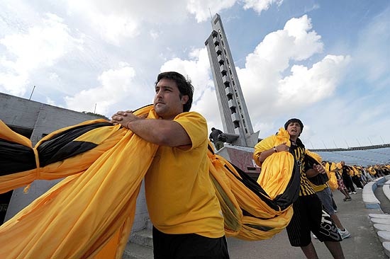 ORG XMIT: PP006 Uruguayan Penarol?s team fans carry what is supposed to be the largest football supporters' flag (309 X 46 m) outside Centenario stadium in Montevideo on April 12, 2011. The fans made the flag, which costed about 30,000 dollars and will be displayed on Tuesday for the first time during the Libertadores Cup match against Argentinian team Independiente. AFP PHOTO/Pablo PORCIUNCULA