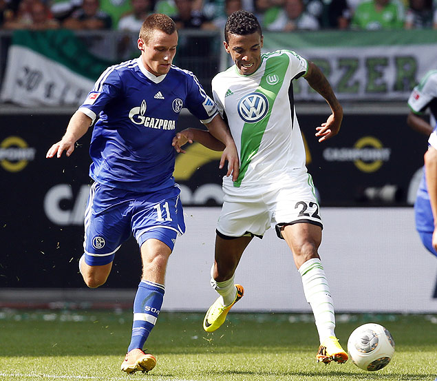 Luiz Gustavo (de branco) luta pela bola em jogo contra o Schalke 04